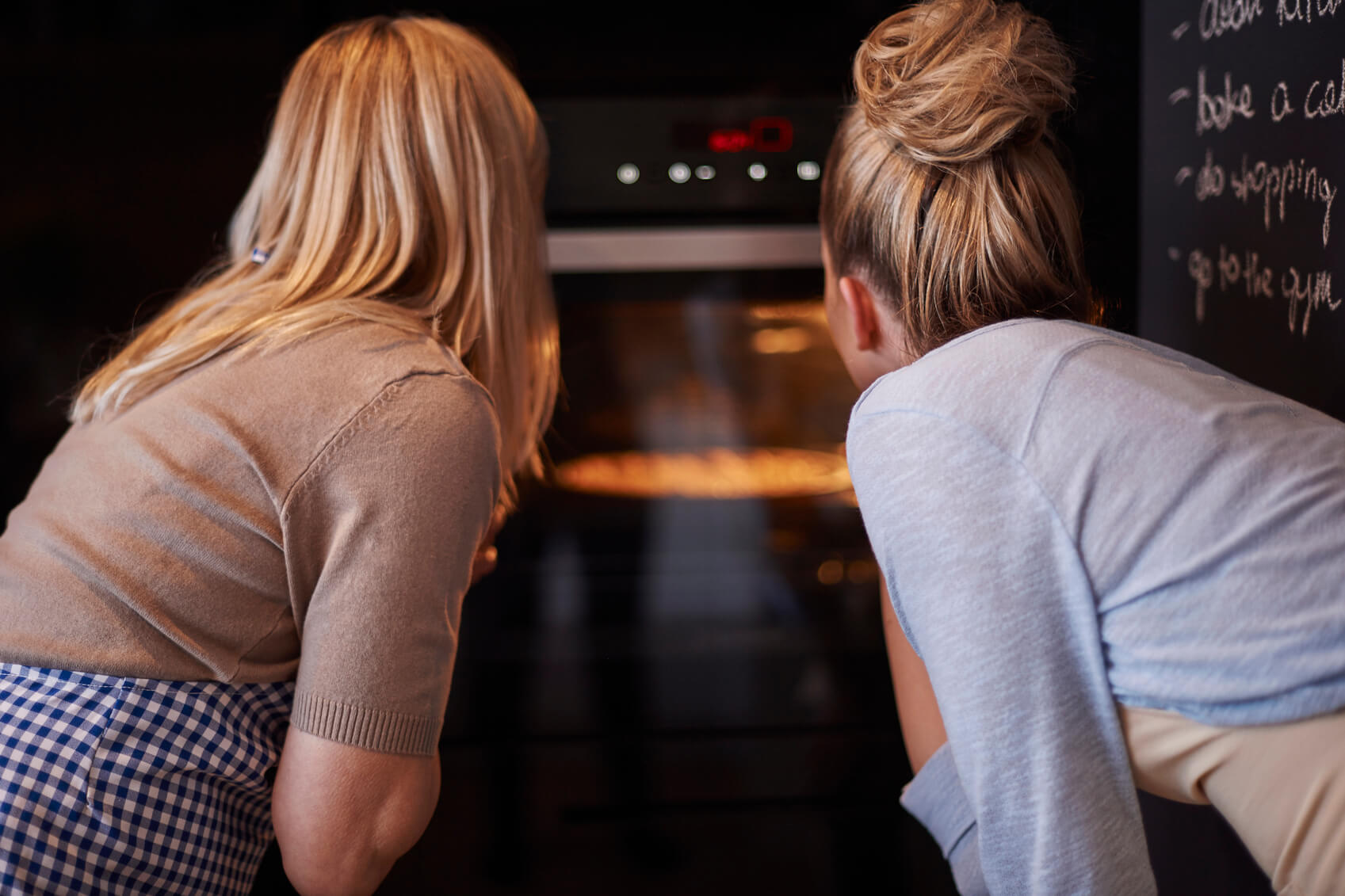 mujeres mirando la cocción en un horno