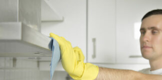 Hombre limpiando la campana extractora de su cocina