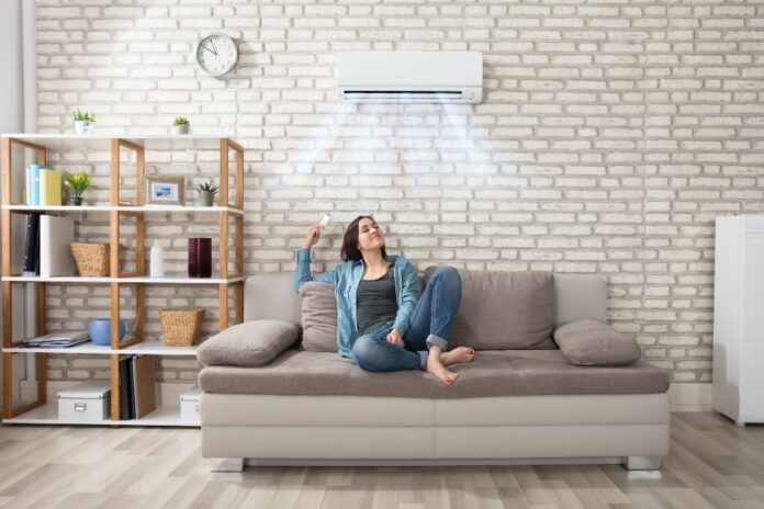 mujer debajo de aire acondicionado en salón